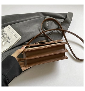 Detail of dual-compartment crossbody bag in beige fabric with brown leather trim