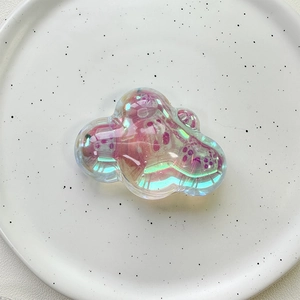 Close-up of cloud-shaped laser iridescent phone grip accessory with pearlescent finish