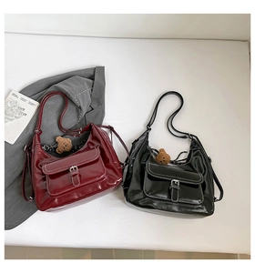 Detail of glossy PU leather tote bags in burgundy and black with white contrast stitching