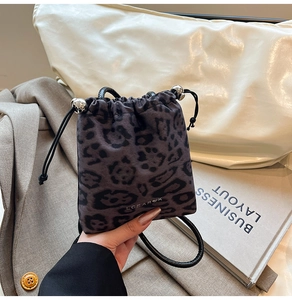 Close-up of leopard print drawstring bag with silver metal beads and black shoulder strap
