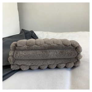 Détail du sac cabas en peluche gris foncé montrant la texture rayée de la fausse fourrure