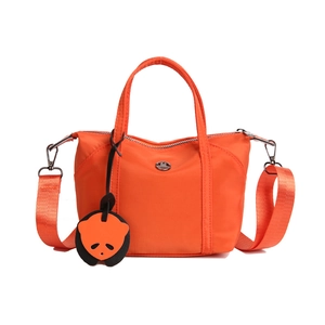 Vibrant orange nylon mini tote bag with a playful panda charm and adjustable strap