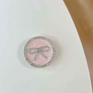 Nahaufnahme einer rosa Handyhalterung mit glitzernder Strassschleife und Kristalldekor