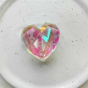 Detailed macro view of a heart-shaped laser crystal phone grip with pink glitter accents