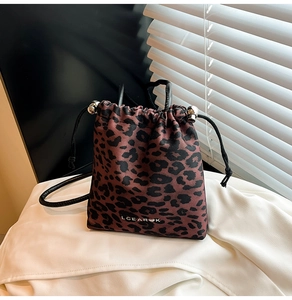 Close-up of leopard print bucket bag with drawstring closure and metal buckle detail