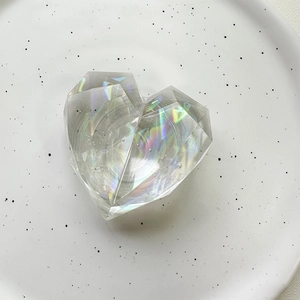 Close-up of heart-shaped laser crystal phone socket stand with multifaceted iridescent finish