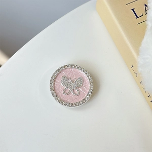 Makroaufnahme der Handyhalterung mit rosa Textur und glitzerndem Schmetterling