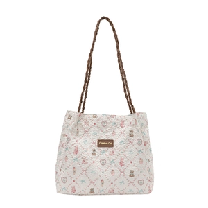 Quilted tote bag with colorful cartoon prints and woven straps on a clean background