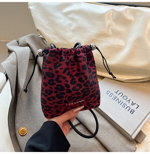 Detail of red leopard print bucket bag featuring silver metal toggle and drawstring closure