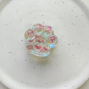 Close-up of an iridescent holographic cat paw phone grip with a heart relief detail
