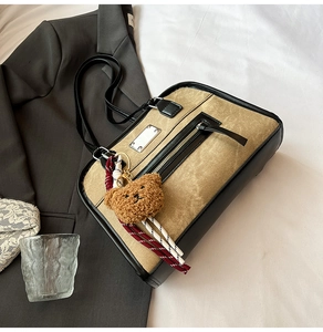 Retro tan suede shoulder bag featuring a zipper closure and a cute brown plush bear charm