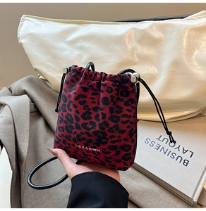 Detail of red leopard print bucket bag with drawstring closure and silver ball adjuster