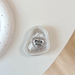 Detail of silver heart phone socket with sparkling rhinestones and clear resin base