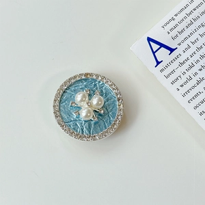 Nahaufnahme der Perlenblüte mit Strass auf einem hellblauen faltbaren Handy-Halter