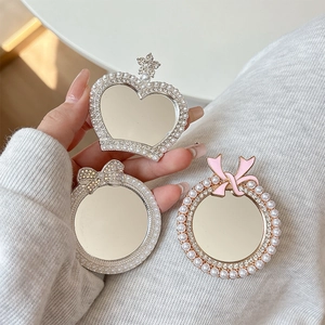 Detailed view of pearl crown and bow mirror phone socket holders with rhinestones