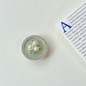 Detail von grünem Krokodil-Handyhalter mit Perlenblume und glänzenden Strasssteinen