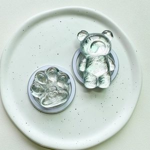 Macro shot of bear and cat paw resin magnetic phone sockets on a white textured tray