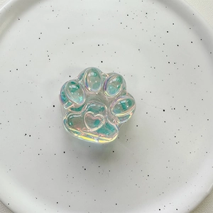 Detail of laser iridescent cat paw phone grip with heart relief on white ceramic tray