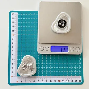 Weight measurement of cute bow and heart resin phone sockets showing 12.7g on scale