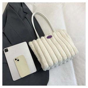 Détail macro du sac cabas en fausse fourrure blanche avec texture rayée et écusson