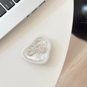 Macro shot of silver rhinestone Smile phone griptok with pearlescent texture detail