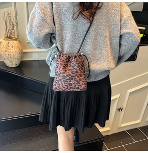 Détail du sac seau léopard avec fermeture à cordon et fine bandoulière en cuir