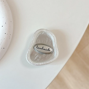 Minimalist flower butterfly phone grip showing the handmade silver engraved emblem