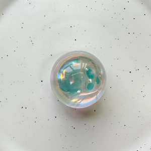 Macro shot of iridescent crystal ball phone grip showing colorful pearlescent finish