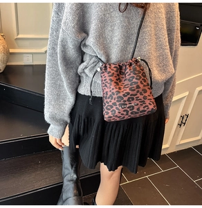 Close-up of leopard print nylon drawstring bucket bag with branded white lettering