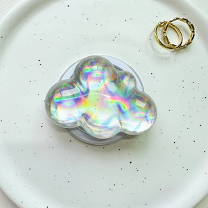 Close-up of cloud-shaped iridescent pop socket with laser rainbow effect on a white base