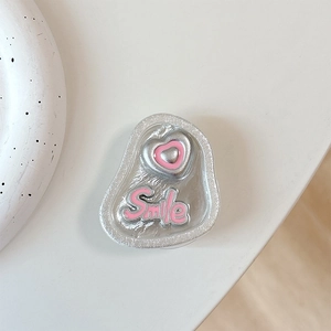 Detail of silver phone grip featuring a pink embossed heart and Smile lettering texture