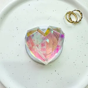 Macro shot of a multifaceted heart-shaped phone grip with iridescent laser finish and white base