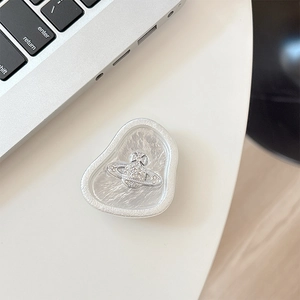 Detail of silver phone grip featuring a crystal planet logo on a laptop keyboard