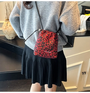 Détail du sac seau léopard rouge avec fermeture à cordon et bandoulière réglable