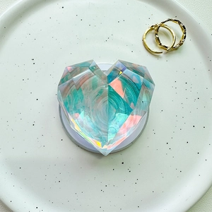 Close-up of heart-shaped holographic crystal phone grip with multi-faceted resin design