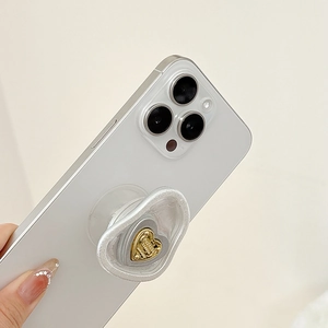 Detail of heart-shaped phone grip with pearlescent border and mini gold heart accent