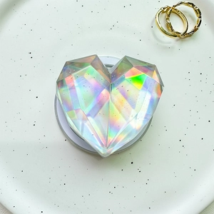 Close-up of holographic heart-shaped phone grip with multi-faceted crystal design