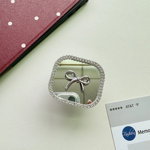 Close-up of square phone grip with mirror, silver bow and sparkling rhinestones
