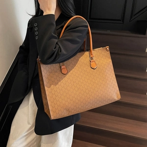 Brown faux leather tote bag featuring repeating M letter prints and shoulder straps