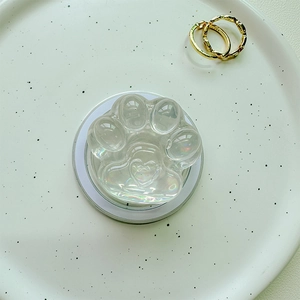 Macro view of iridescent cat paw phone socket with heart detail on a white plate
