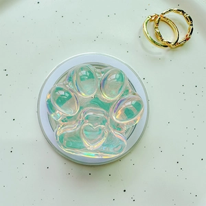 Macro view of holographic cat paw phone grip with heart shape on a textured tray