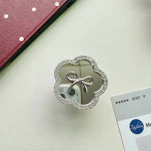 Macro detail of floral griptok with mirror center, silver bow and sparkling rhinestones