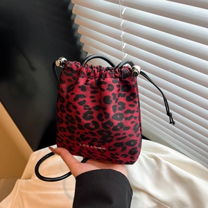 Fashionable red leopard print drawstring bucket bag with adjustable black shoulder strap