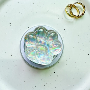 Macro detail of holographic cat paw phone socket with crystal heart texture on white plate