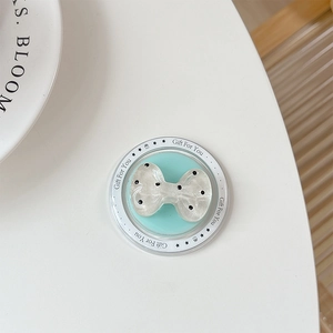 Detail of blue bow-shaped collapsible phone grip with black polka dots and gift text