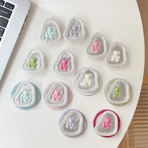 Cute magnetic bear phone grip set with transparent wave bases on minimalist white desk