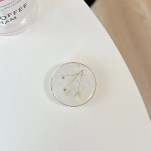 Macro detail of round resin phone socket featuring real white flowers and pearls