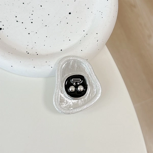 Macro shot of silver metallic phone grip with cherry design on a ceramic plate
