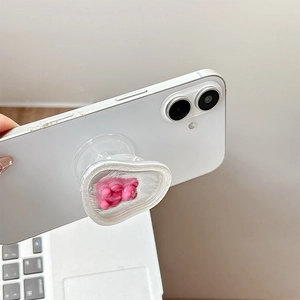 Detail of magnetic heart phone grip with cute pink bear on white smartphone back