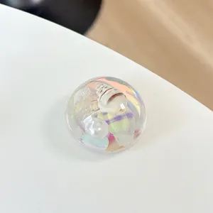 Macro detail of a 3D seashell and pearl inside a clear resin spherical phone grip